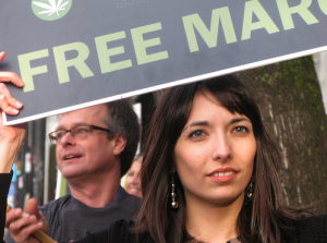 Pot activists Jodie and Marc Emery hold signs along the Olympic Torch route outside Cannabis Culture Headquarters in Vancouver. (Photo by Jeremiah Vandermeer)